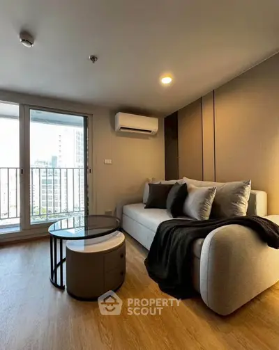 Modern living room with cozy sofa and city view balcony in high-rise apartment