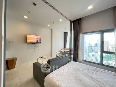 Modern bedroom with city view and stylish furniture in high-rise apartment.