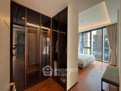 Modern bedroom with floor-to-ceiling windows and sleek closet design.