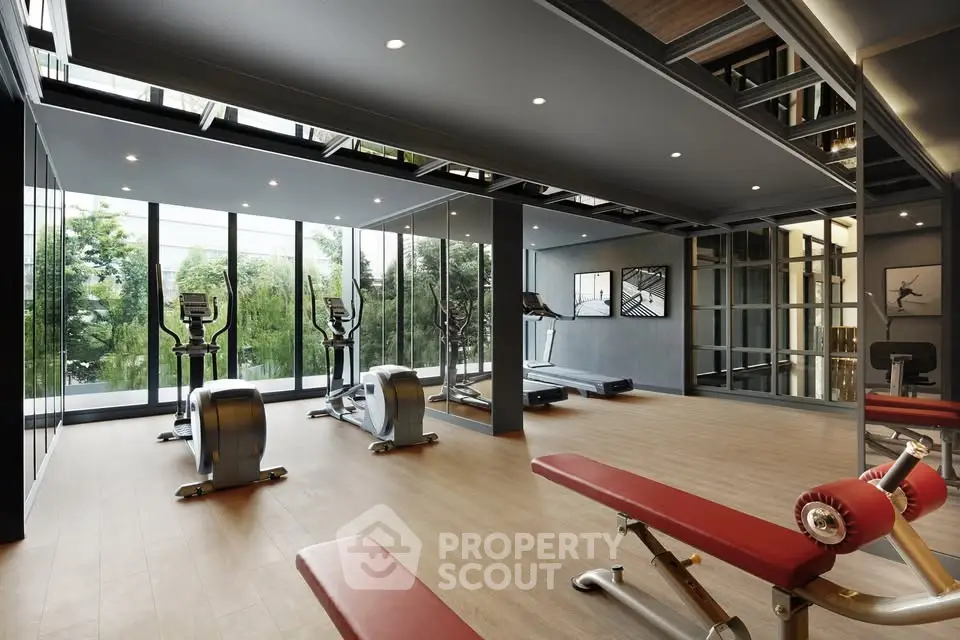 Luxurious modern gym with state-of-the-art equipment and floor-to-ceiling windows offering scenic views.