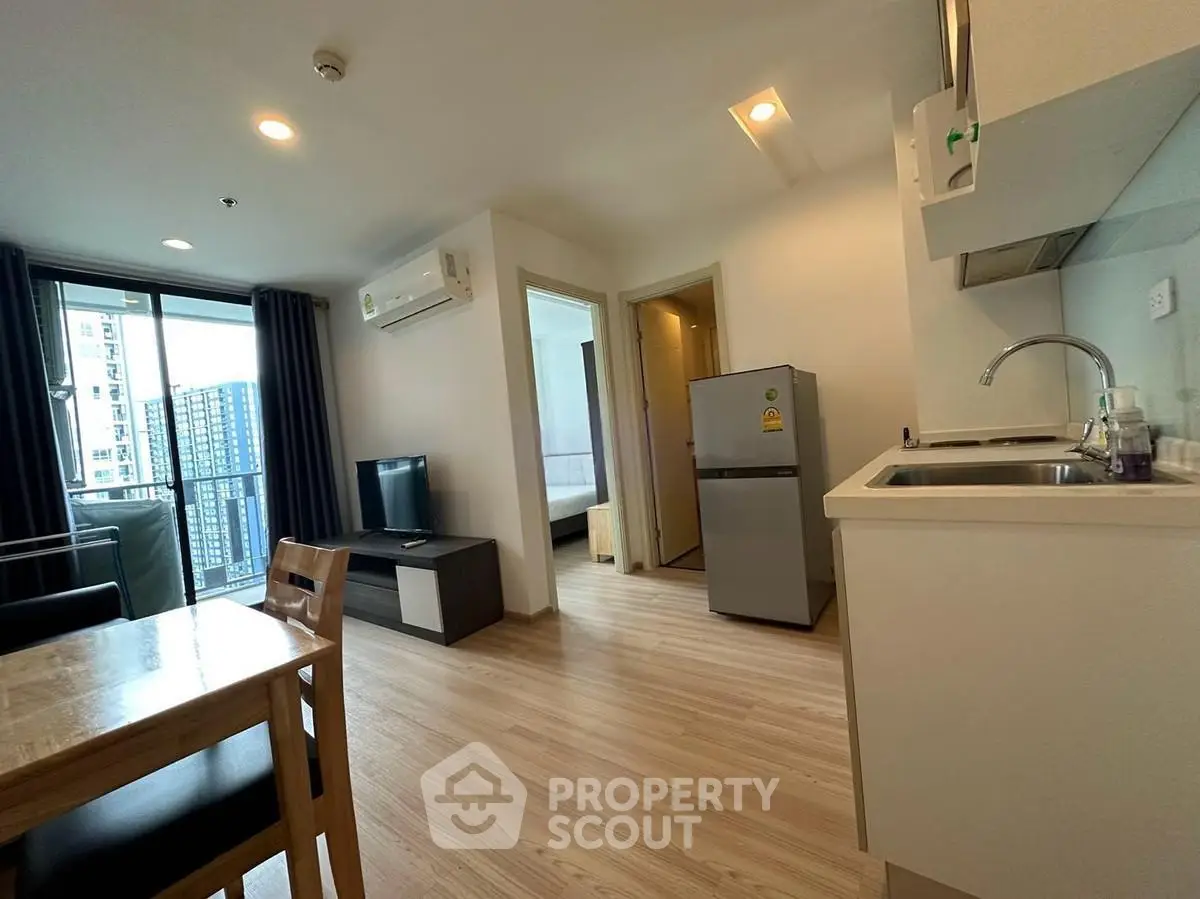 Modern apartment interior with open kitchen and living area, featuring sleek design and natural light.