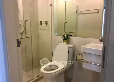 Modern bathroom with glass shower and sleek fixtures in a contemporary home.