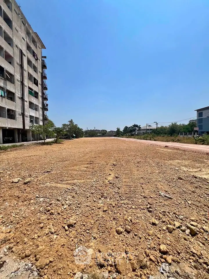 Expansive land plot with development potential under clear blue skies.