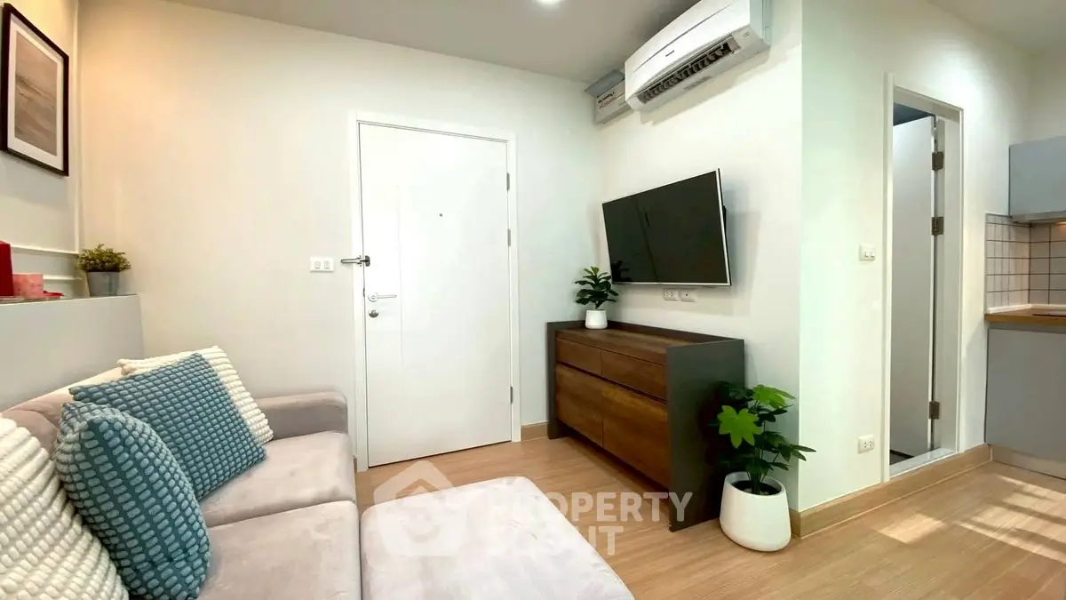 Modern living room with cozy sofa and wall-mounted TV in stylish apartment.