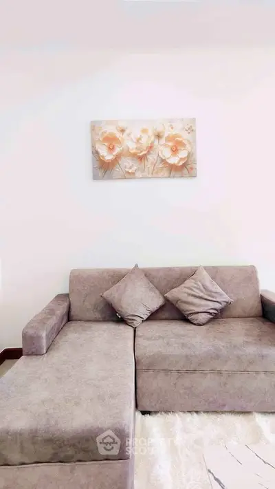 Modern living room with stylish gray sofa and floral wall art, perfect for cozy relaxation.