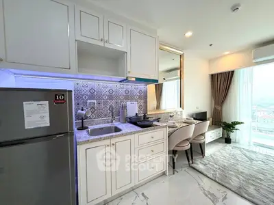 Modern kitchen with elegant white cabinetry and stylish backsplash in a bright apartment.