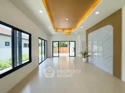 Spacious modern living room with large windows and elegant ceiling design