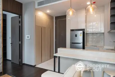 Modern kitchen with sleek design, featuring built-in appliances and stylish lighting in a contemporary apartment.