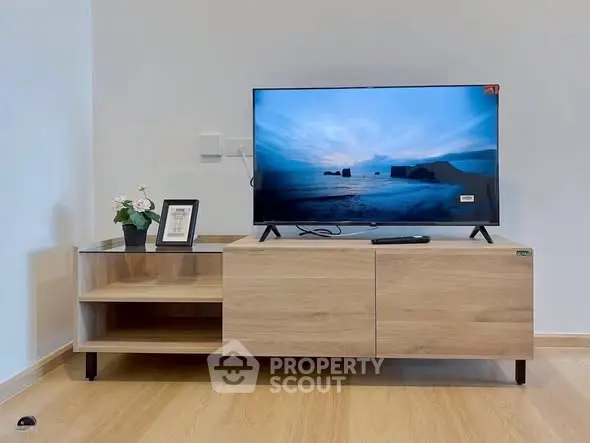 Modern living room with sleek wooden TV stand and flat-screen television, perfect for contemporary homes.