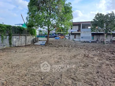 Vacant land plot with potential for development, surrounded by residential buildings and greenery.