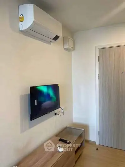 Modern living room with wall-mounted TV and air conditioning unit, showcasing sleek design and comfort.