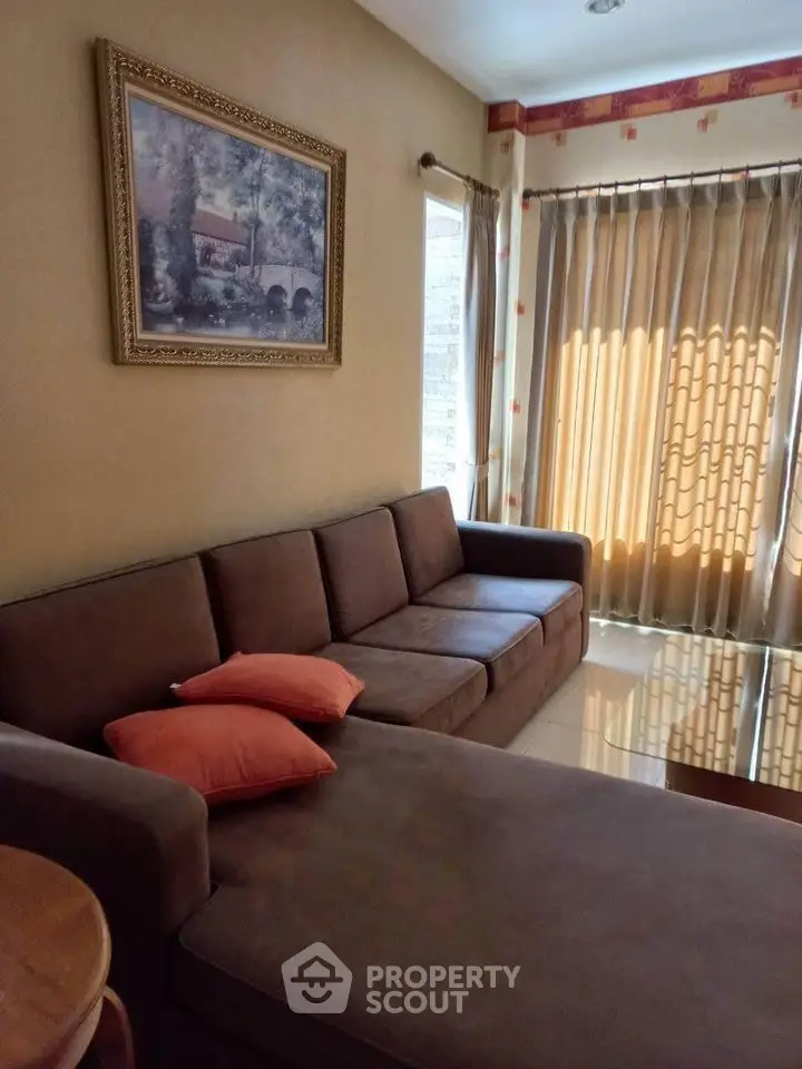 Cozy living room with brown sofa and elegant curtains, perfect for relaxation.