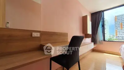Modern bedroom with stylish furniture and large window offering city view