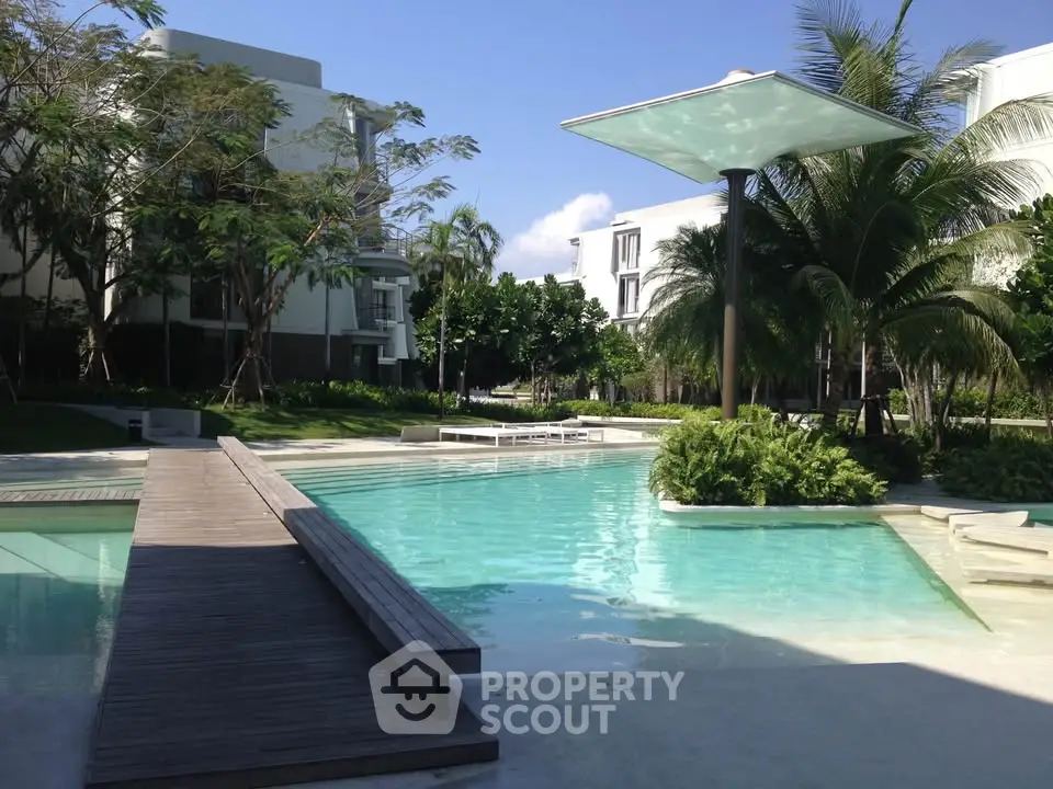 Luxurious residential pool area with modern design and lush greenery, perfect for relaxation and leisure.