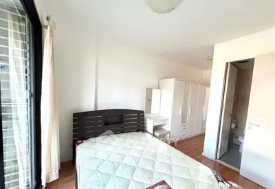 Bright bedroom with modern furniture and ensuite bathroom in a stylish apartment.