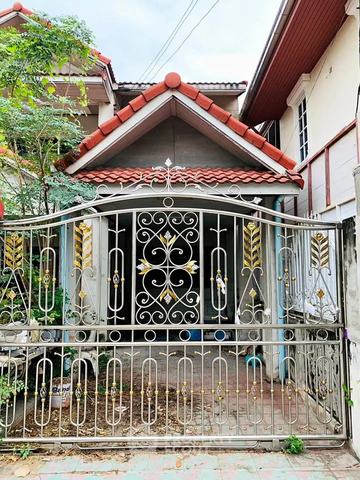 Charming residential house with ornate metal gate and red-tiled roof.