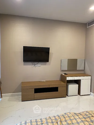 Modern bedroom with wall-mounted TV and sleek wooden furniture