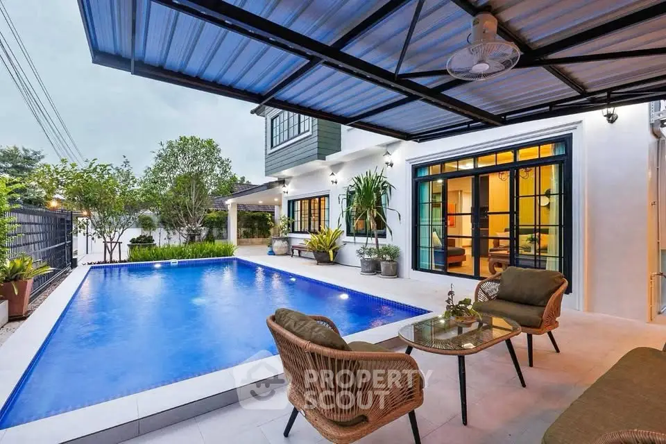 Luxurious modern home with private pool and stylish outdoor seating area, perfect for relaxation and entertainment.