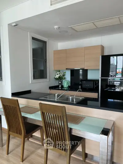 Modern kitchen with sleek black countertops and wooden cabinetry