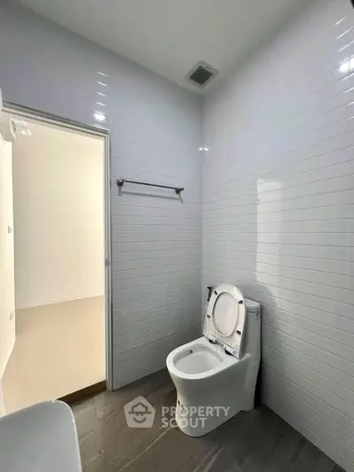 Modern bathroom with sleek white tiles and contemporary toilet design.