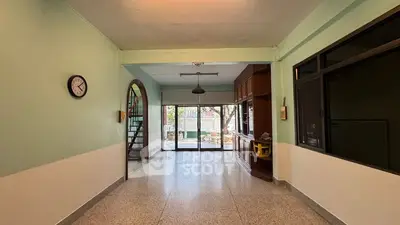 Spacious living room with large windows and staircase, perfect for family gatherings.