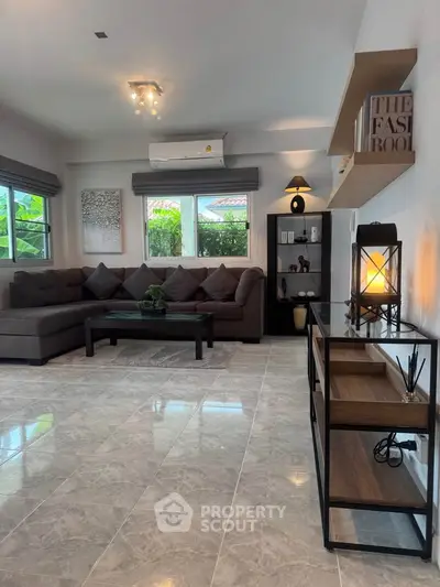 Spacious modern living room with elegant decor and large windows.