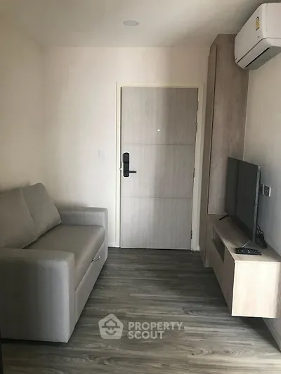 Modern compact living room with sofa, TV, and air conditioning