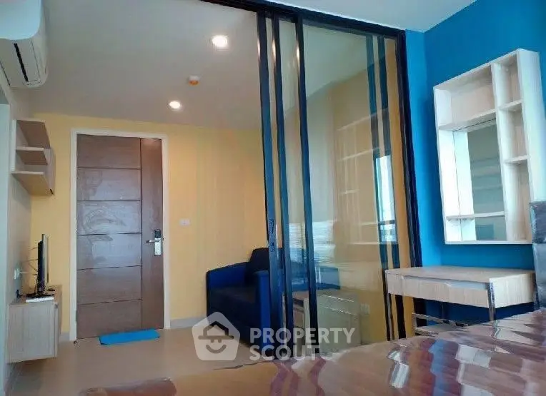 Modern apartment interior with sliding glass doors and vibrant blue accent wall.