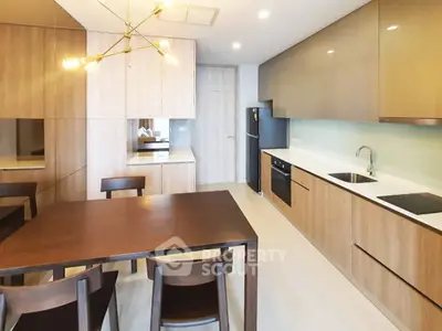 Modern kitchen with sleek cabinetry and dining area in contemporary apartment