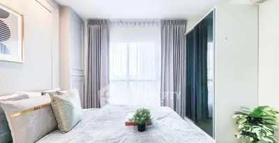 Bright and cozy bedroom with modern decor and large window view.