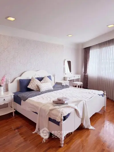 Elegant bedroom with stylish decor and natural light, featuring a cozy bed and hardwood floors.
