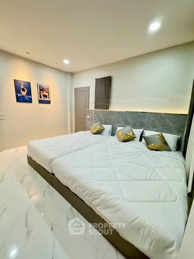 Spacious modern bedroom with twin beds and elegant decor