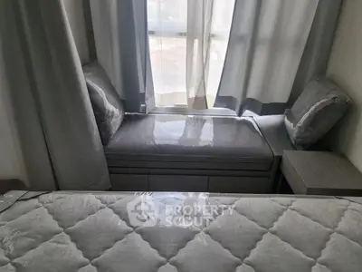 Cozy bedroom with window seating and elegant bedding in modern apartment.