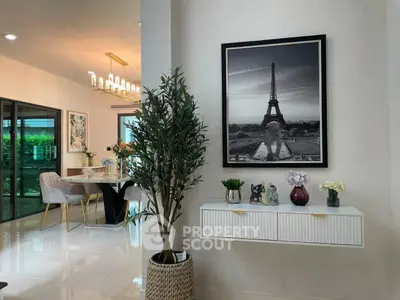 Elegant dining area with modern decor and large window view, featuring stylish furniture and tasteful artwork.