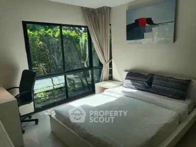 Bright bedroom with large window and modern decor in a serene setting.