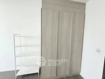 Modern minimalist storage space with sleek wooden wardrobe and white shelving unit.