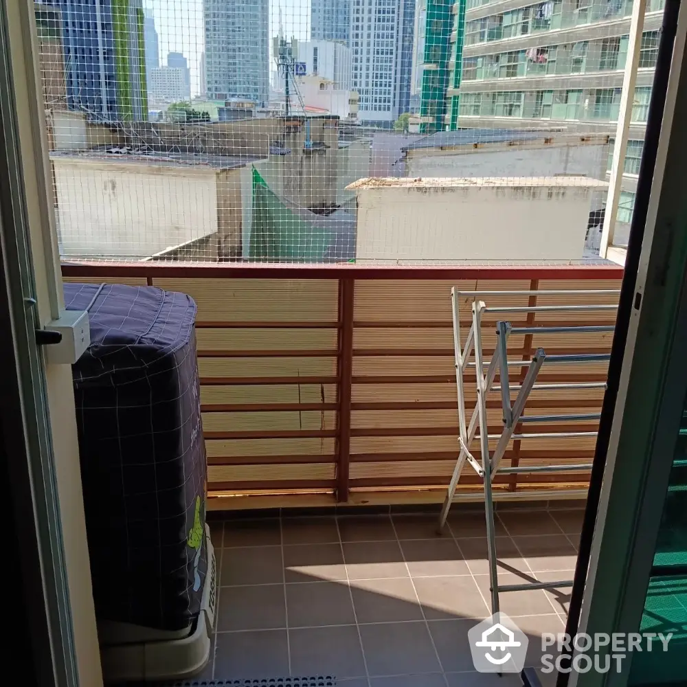 Urban balcony with city view and drying rack, perfect for compact living spaces.