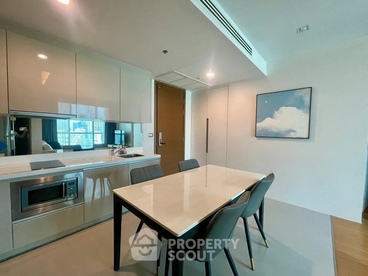 Modern kitchen with sleek cabinetry and dining area in luxury apartment