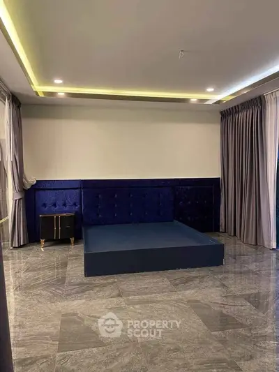 Luxurious bedroom with elegant blue velvet headboard and sleek marble flooring