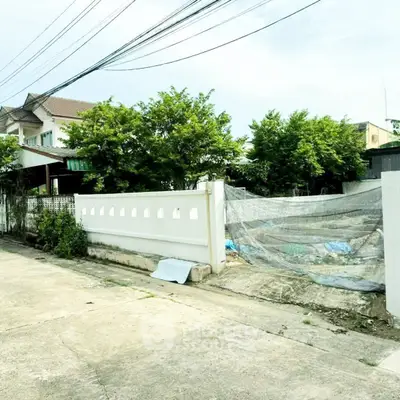 Charming suburban house with lush greenery and white fence in a peaceful neighborhood.