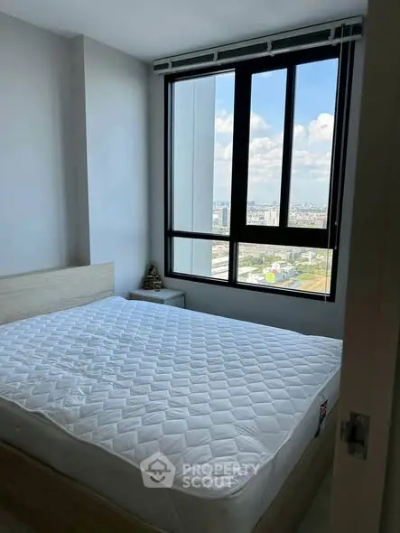 Bright bedroom with large window offering stunning city views, featuring a comfortable bed and minimalist decor.