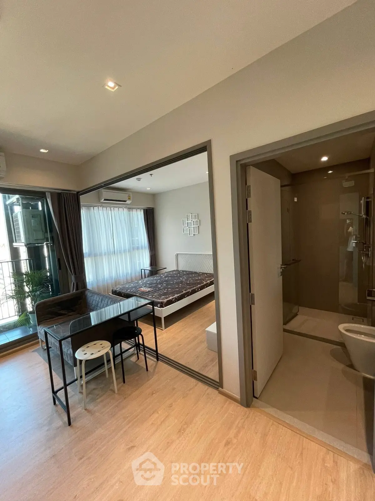 Modern studio apartment with open layout, featuring a cozy bedroom, compact kitchen, and sleek bathroom.