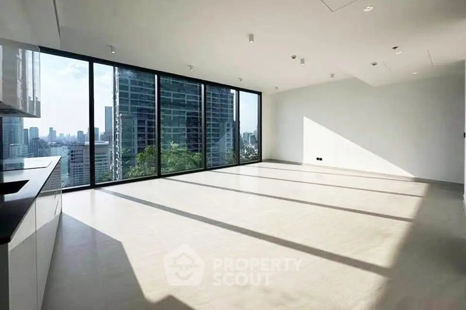 Spacious modern living room with floor-to-ceiling windows and city skyline view