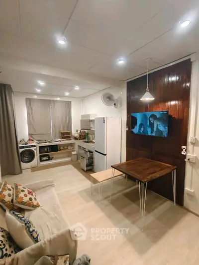 Cozy living room with modern kitchen and washing machine, perfect for urban living.