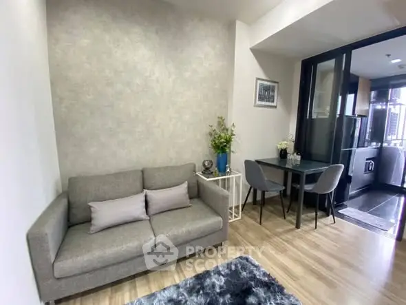 Modern living room with cozy gray sofa and dining area in stylish apartment.