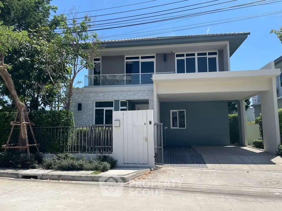 Modern two-story house with spacious driveway and lush greenery in a serene neighborhood.