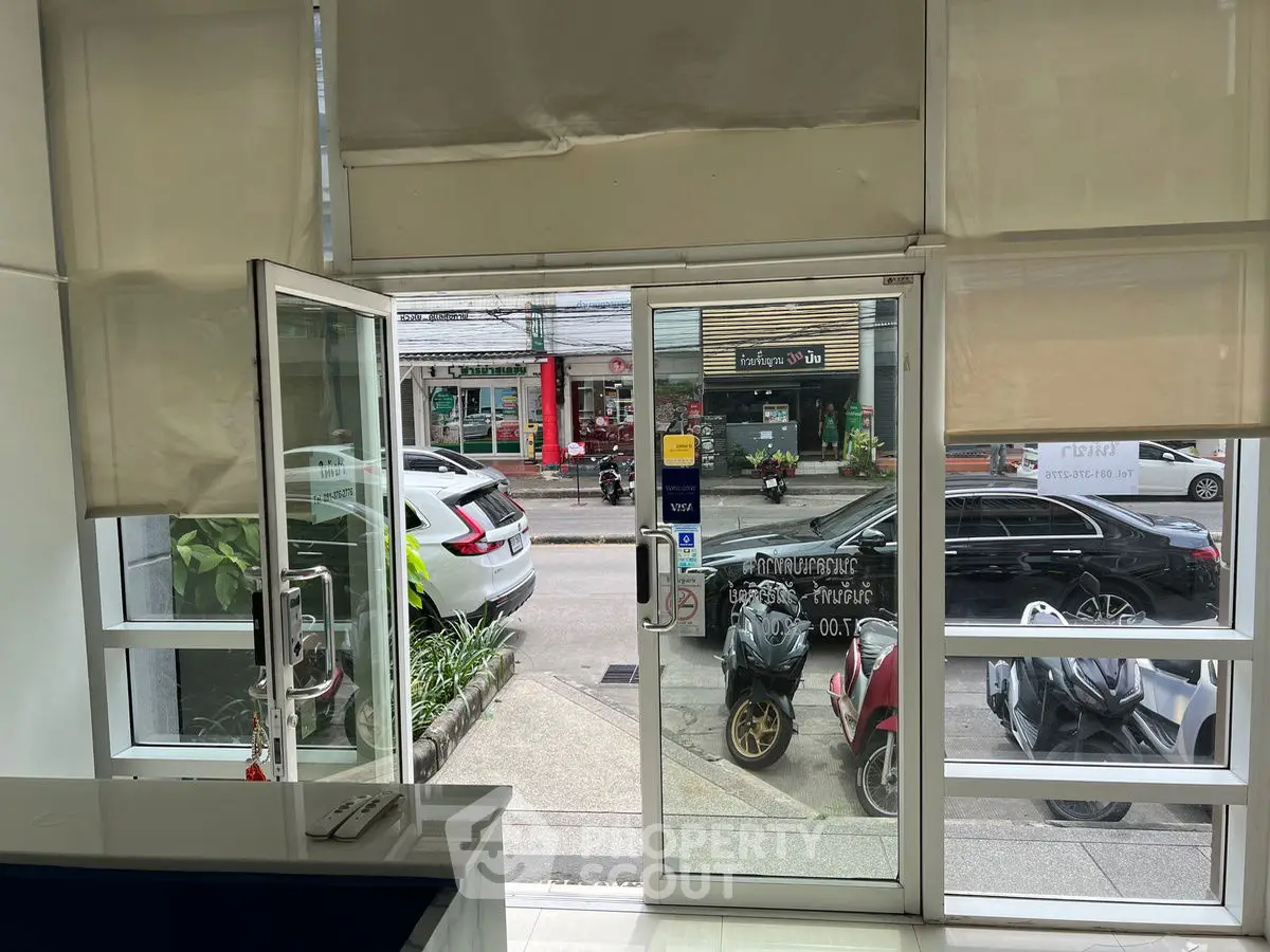 Modern office entrance with glass doors and street view, ideal for business visibility.