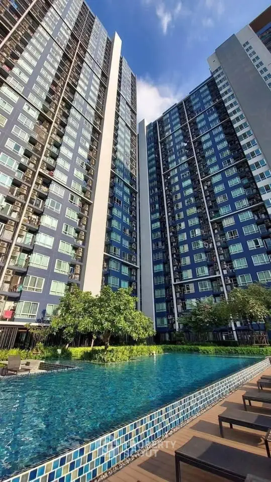 Modern high-rise condominium with a luxurious pool and lush greenery, perfect for urban living.