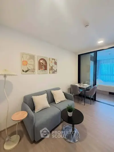 Modern living room with cozy sofa and dining area in open layout apartment.