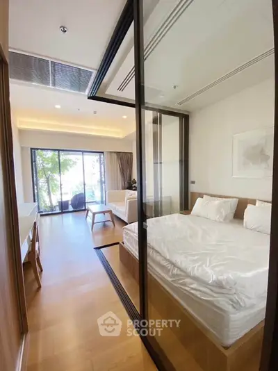 Modern bedroom with glass partition and natural light in stylish apartment